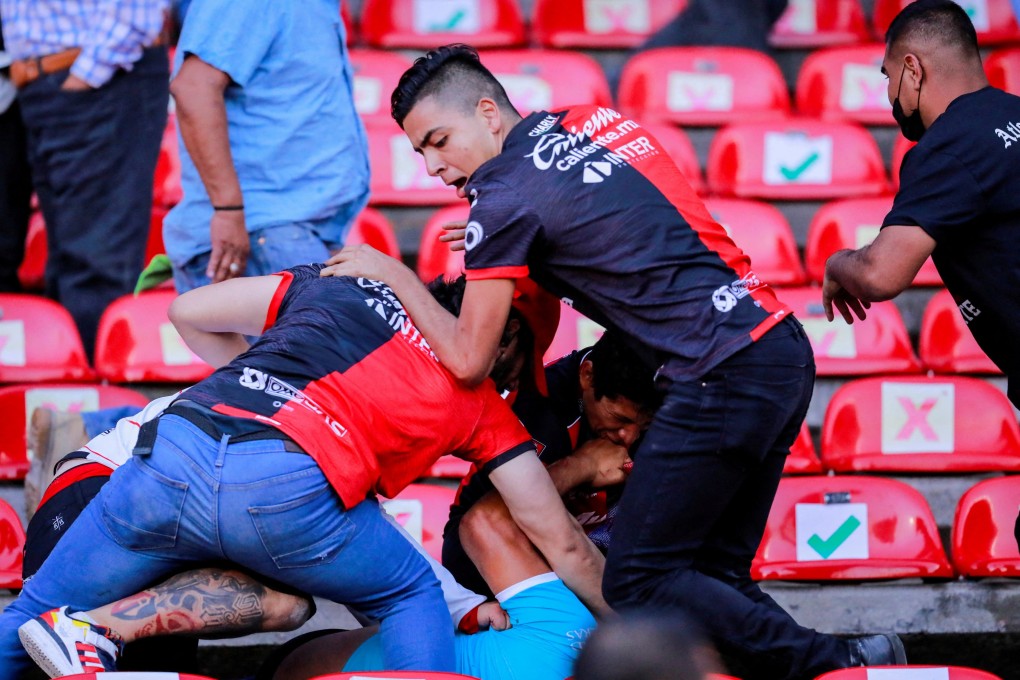 People are beaten at the Corregidora stadium in Queretaro, Mexico, leaving at least 22 injured in a brawl when soccer fans stormed the field on March 5. Photo: Reuters