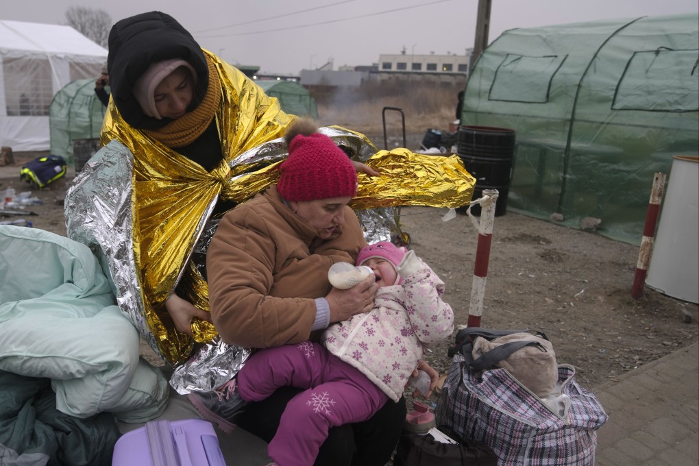 A woman feeds a baby after fleeing from the Ukraine and arriving at the border crossing in Medyka, Poland. Photo: AP