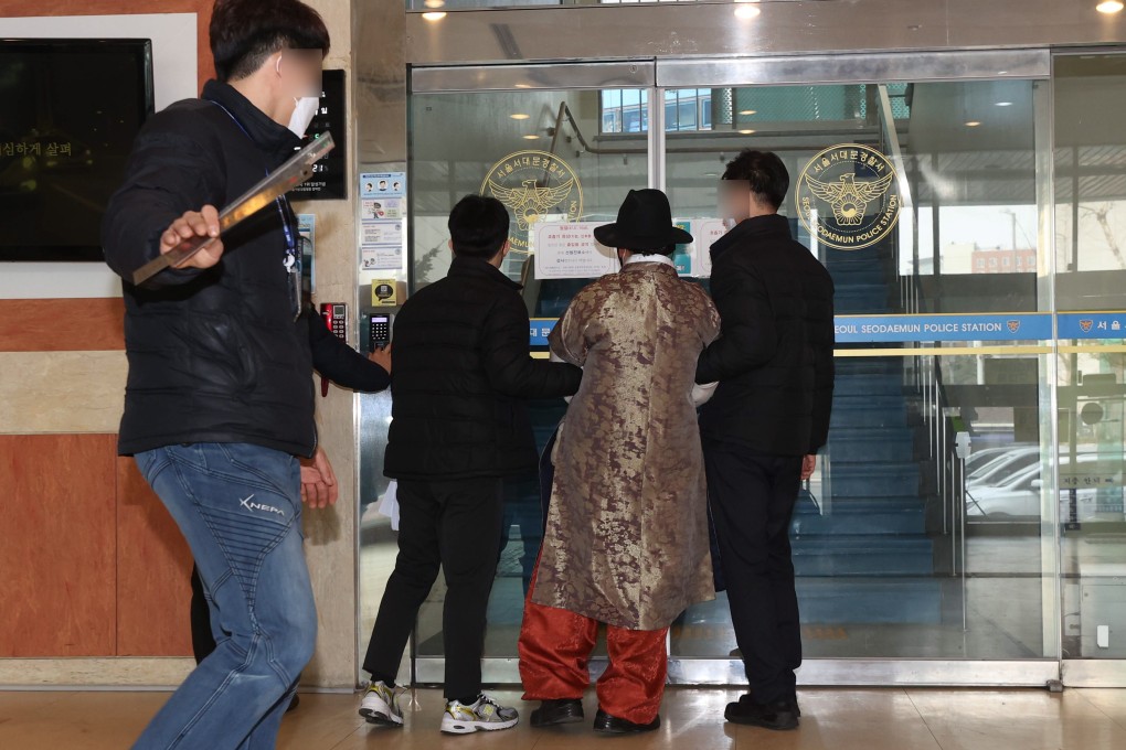 A man wearing a robe and hat being taken into a police station in Seoul, South Korea, on Monday, to be questioned in relation to an attack on Song Young-gil, head of the ruling Democratic Party. Song was taken to hospital with non-life-threatening injuries, according to party officials.  Photo: EPA-EFE