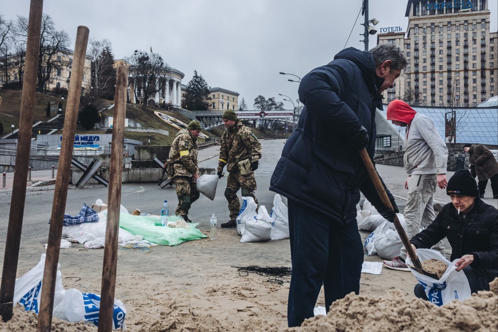Soldiers and volunteers fill sandbags to build barricades at Maidan square in central Kyiv for protection against Russian attacks. Photo: DPA