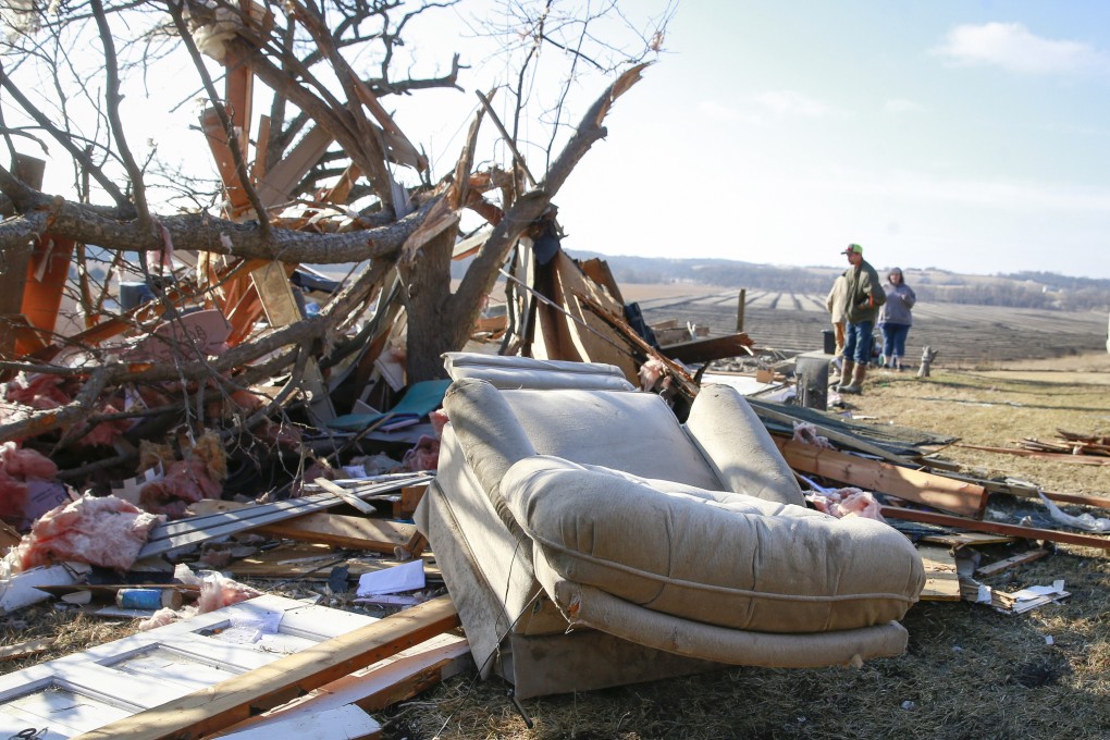 People stand among debris in Winterset, Iowa, US on Sunday after a tornado tore through the area. Photo: The Des Moines Register via AP