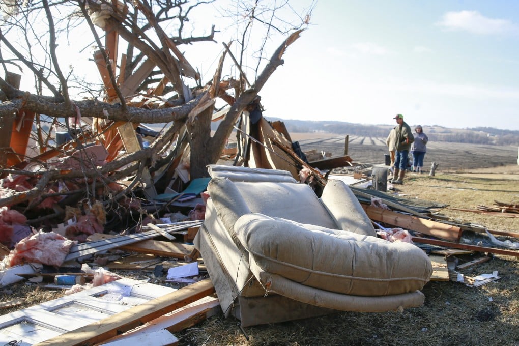People stand among debris in Winterset, Iowa, US on Sunday after a tornado tore through the area. Photo: The Des Moines Register via AP