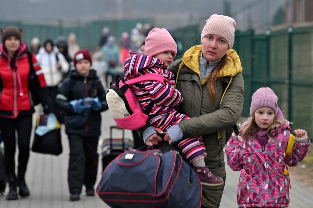 Women with their children are crossing the Ukrainian border into Poland, at Medyka border crossing on Tuesday. Photo: AFP