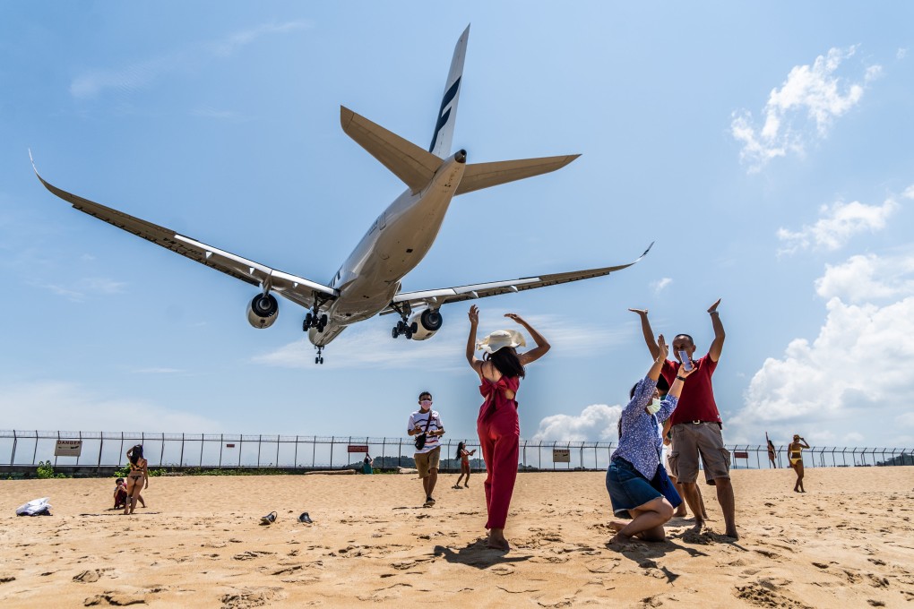 A Finnair plane flies over tourists at Mai Khao beach before landing at the Phuket International Airport in Thailand. Amid a slow pick-up in travel in the Asia-Pacific region, Thai hoteliers want entry rules for foreign tourists made easier. Photo: dpa