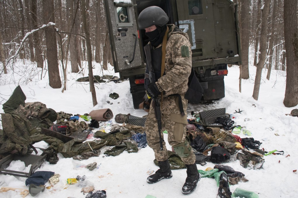 A volunteer of the Ukrainian Territorial Defense Forces inspects a damaged military vehicle in the outskirts Kharkiv, Ukraine’s second-largest city, March 7, 2022. Photo: AP Photo