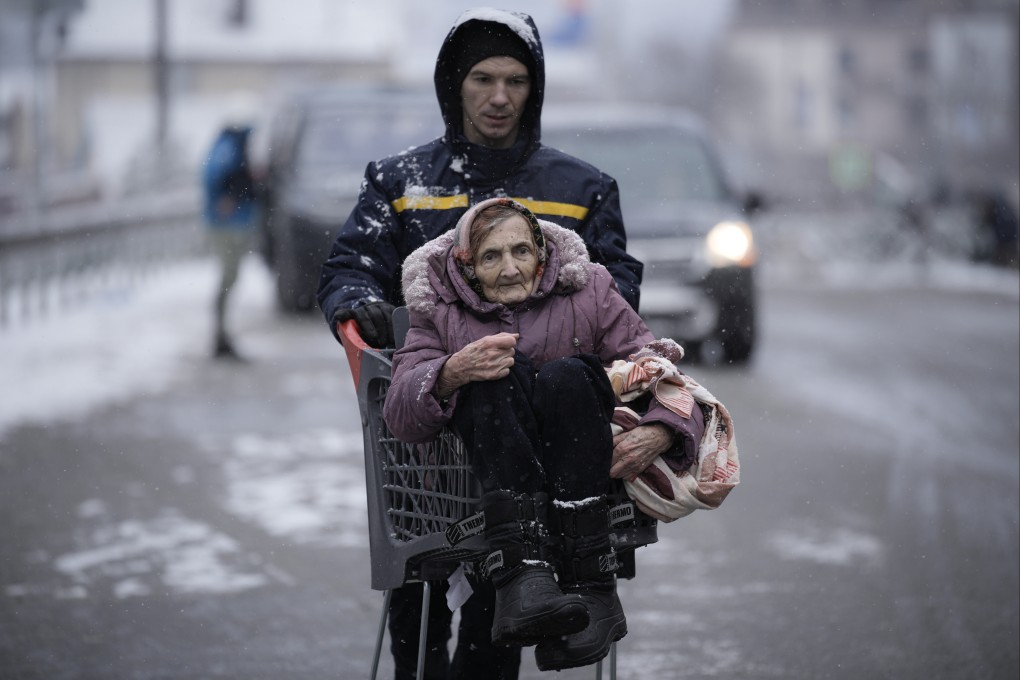 An elderly lady is carried in a shopping cart after being evacuated from Irpin on the outskirts of Kyiv, Ukraine, on Tuesday. Photo: AP