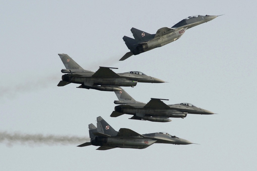 Two Polish Air Force Russian-made MiG-29s fly above and below two Polish Air Force US-made F-16 fighter jets during the air show in Radom, Poland in August 2011. Photo: AP