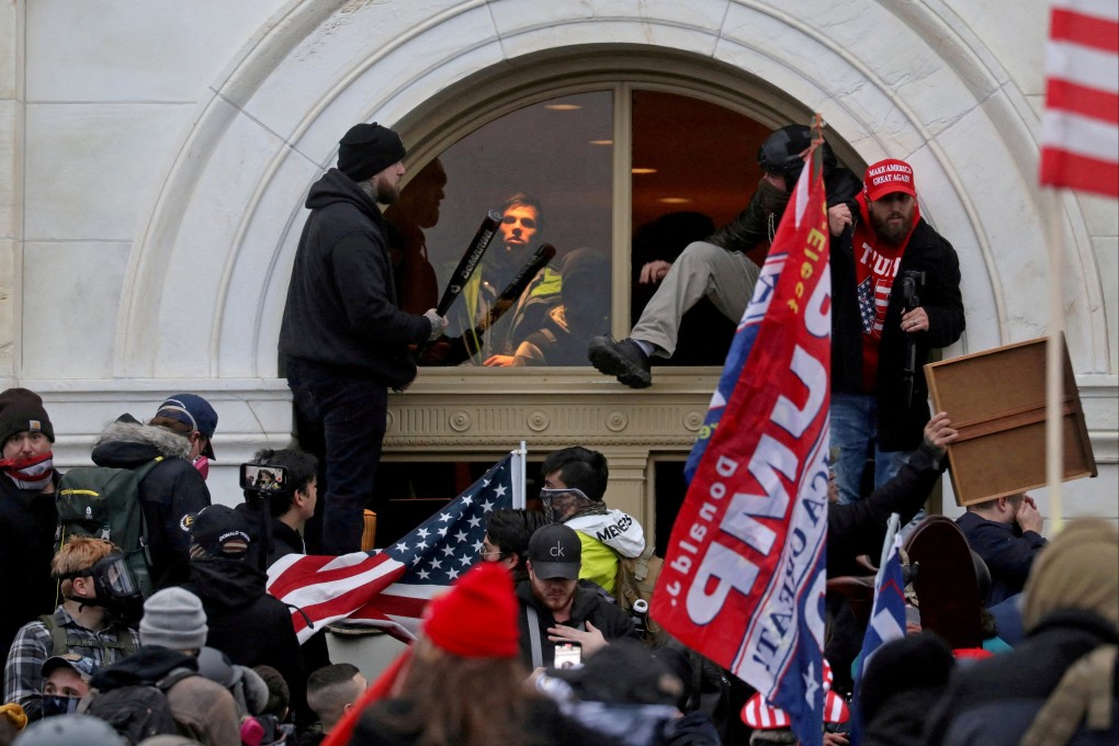 A mob of supporters of then-U.S. President Donald Trump climb through a window they broke as they storm the U.S. Capitol Building in Washington, U.S., on January 6, 2021. Photo: Reuters