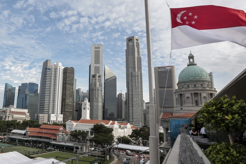 The Singapore flag flies over the National Gallery, seen against the skyline of the financial district in Singapore. Photo: EPA-EFE