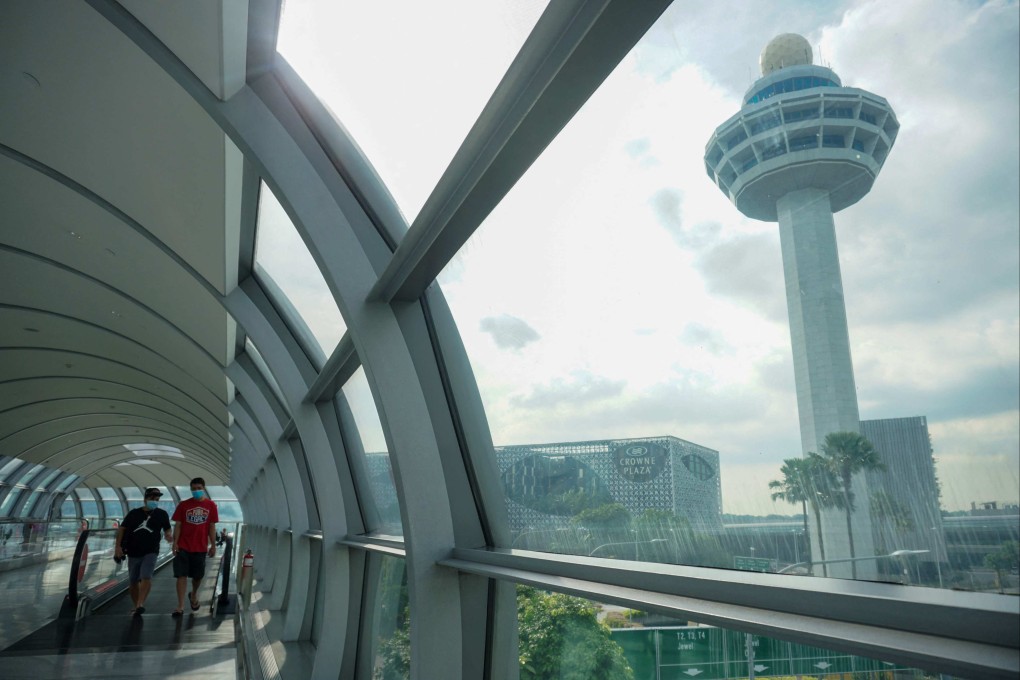 People walk along the link bridge to a terminal at Changi International Airport in Singapore. Photo/ AFP