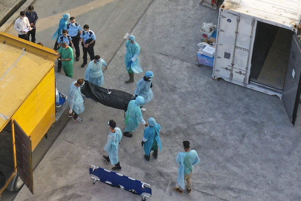 Workers transfer bodies into temporary storage outside a public mortuary in Hong Kong. Photo: Felix Wong