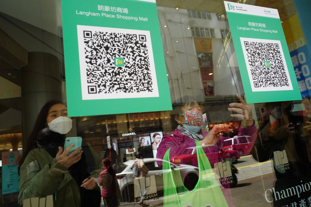 People scan a QR code at a shopping mall in Mong Kok on February 24, the first day of the implementation of the vaccine pass scheme in shopping malls, restaurants and supermarkets.  Photo: Felix Wong