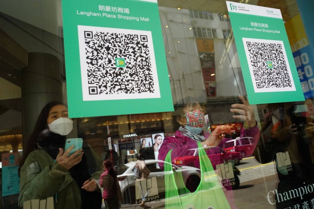 People scan a QR code at a shopping mall in Mong Kok on February 24, the first day of the implementation of the vaccine pass scheme in shopping malls, restaurants and supermarkets. Photo: Felix Wong