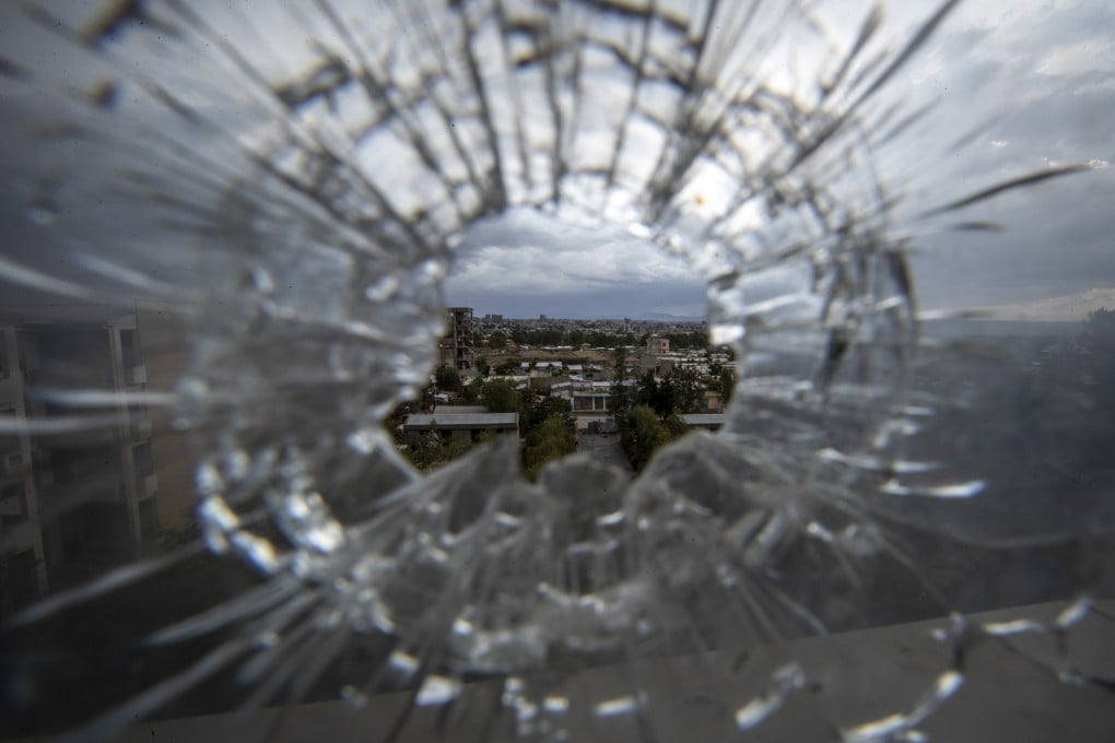 The city of Mekele is seen through a bullet hole in a stairway window of the Ayder Referral Hospital, in the Tigray region of northern Ethiopia. Photo: AP