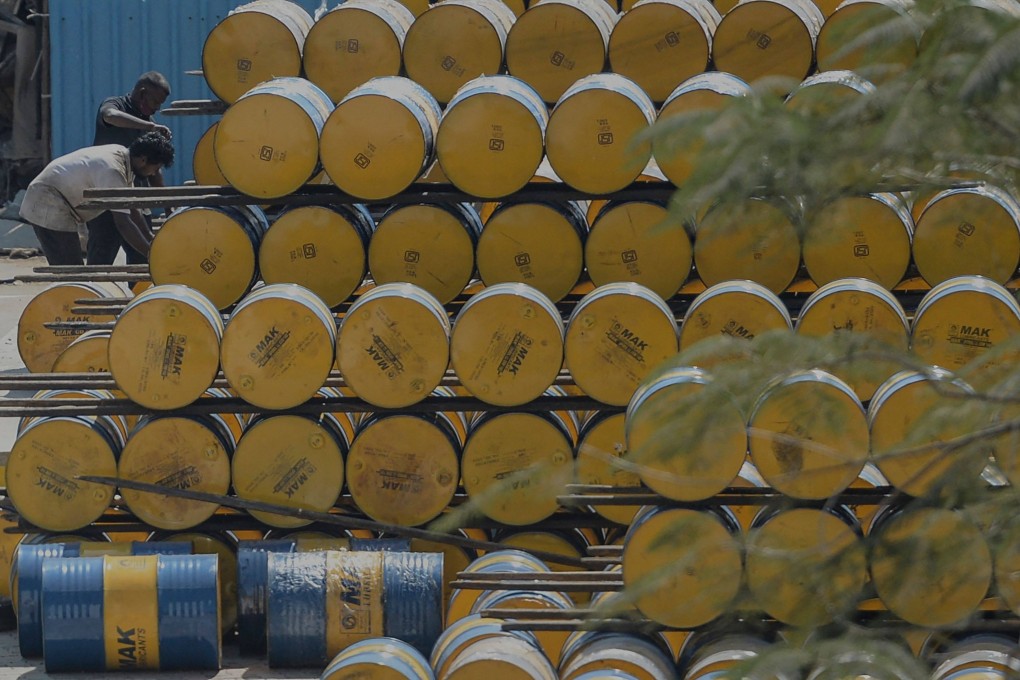 A worker stacks oil barrels at a filling station in Chennai, India. File photo: AFP
