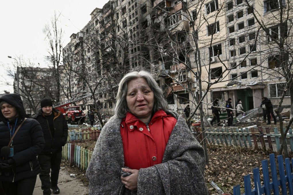 A woman stands in front of a destroyed apartment block, shelled in Kyiv, Ukraine, on Monday. Photo: AFP