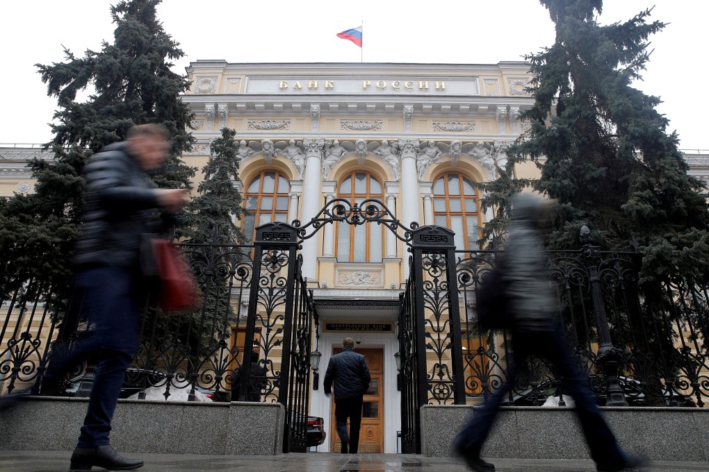 People walk past the Central Bank headquarters in Moscow on March 8. Russia’s central bank assets being held in foreign institutions are now frozen. Photo: Reuters