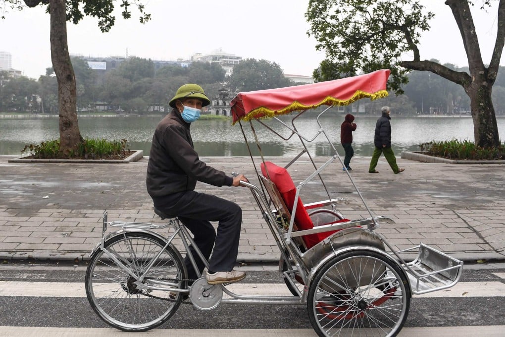 A driver looks for customers along Hoan Kiem Lake in downtown Hanoi. Photo: AFP