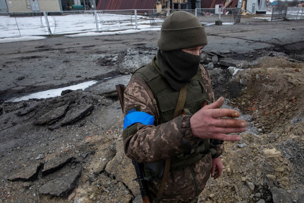 A Ukrainian service member stands next to a bomb crater in the town of Okhtyrka in the Sumy region, Ukraine on March 14. Photo: Iryna Rybakova / Press service of the Ukrainian Ground Forces / Handout via Reuters