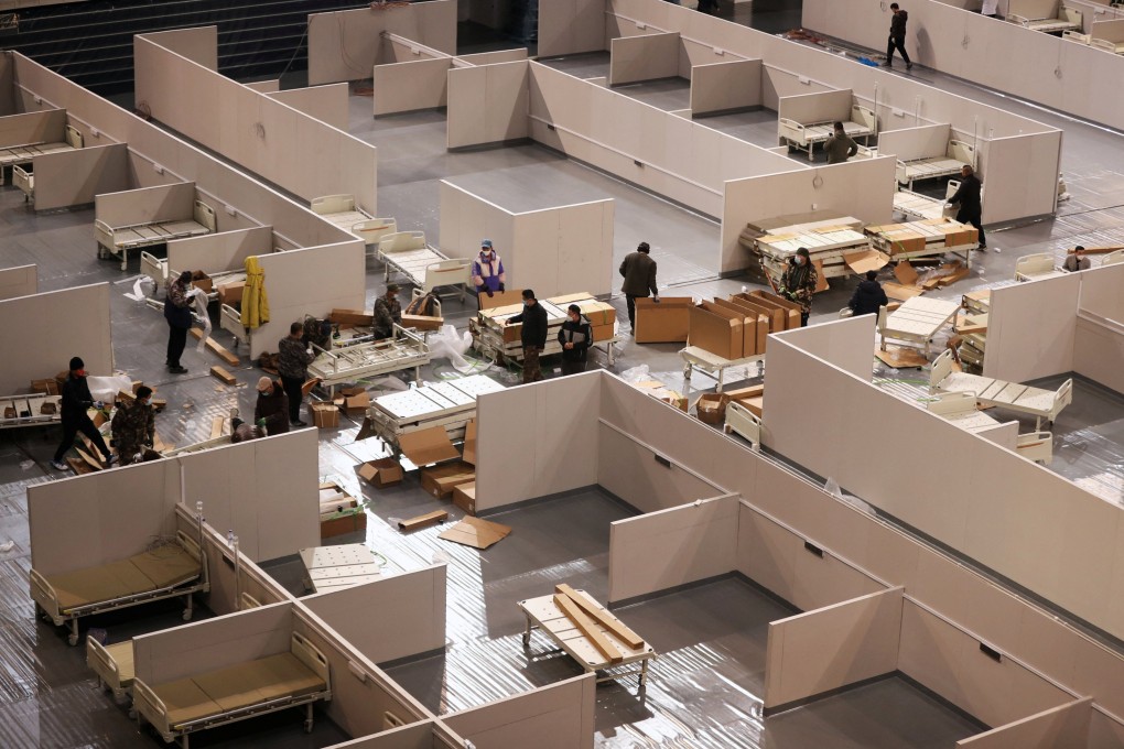 Workers set up beds inside a stadium to convert it into a makeshift hospital in Jilin province. Photo: Reuters