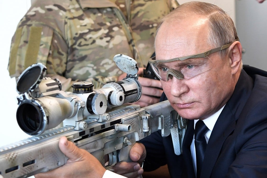 Vladimir Putin aims a sniper rifle while visiting a military exhibition near Moscow, Russia, in September 2018. Photo: Kremlin Pool Photo via AP