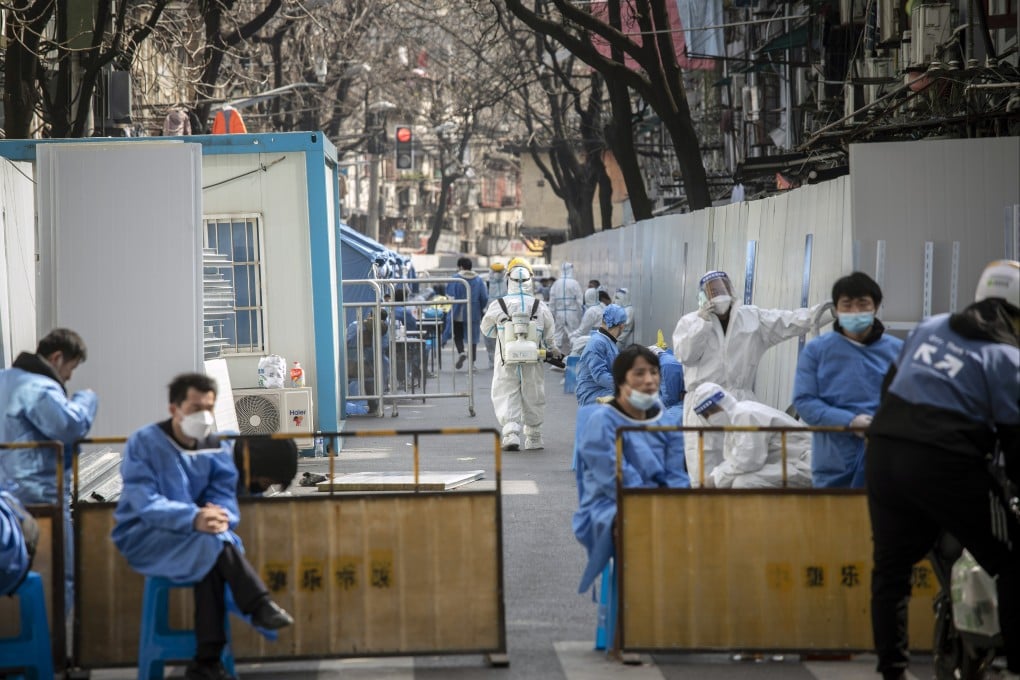 Workers at a locked down neighbourhood in Shanghai on Wednesday. Cases are surging in China as the highly transmissible Omicron variant spreads. Photo: Bloomberg