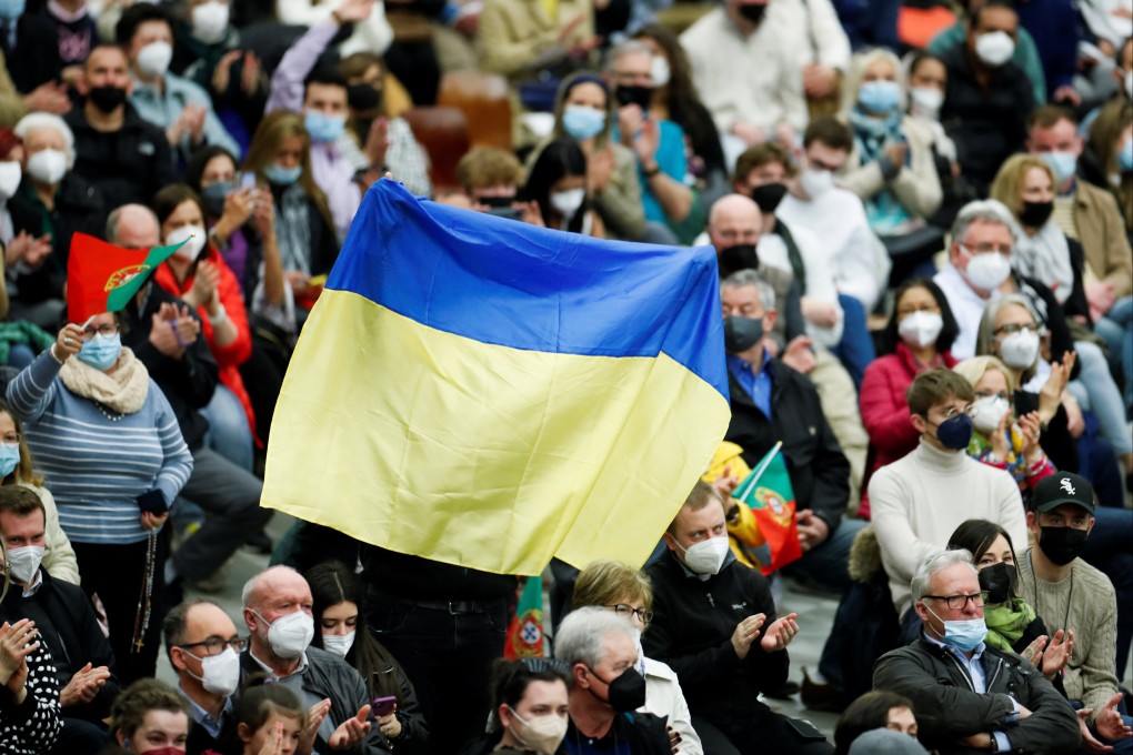 A person holds up a Ukrainian flag as people attend the weekly general audience held by Pope Francis at the Vatican. Photo: Reuters