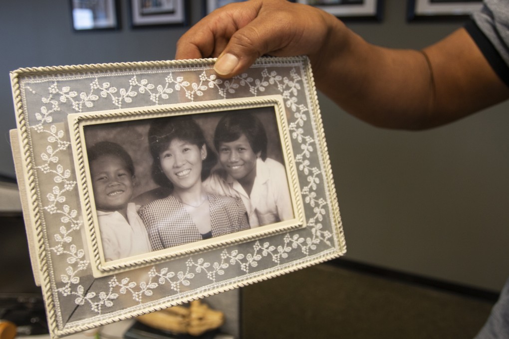 Robert Peterson holds a photo showing his late mother, Yong Ae Yue, on March 10. Yue was one of eight people shot and killed at various massage businesses in the Atlanta area a year ago. Photo: AP