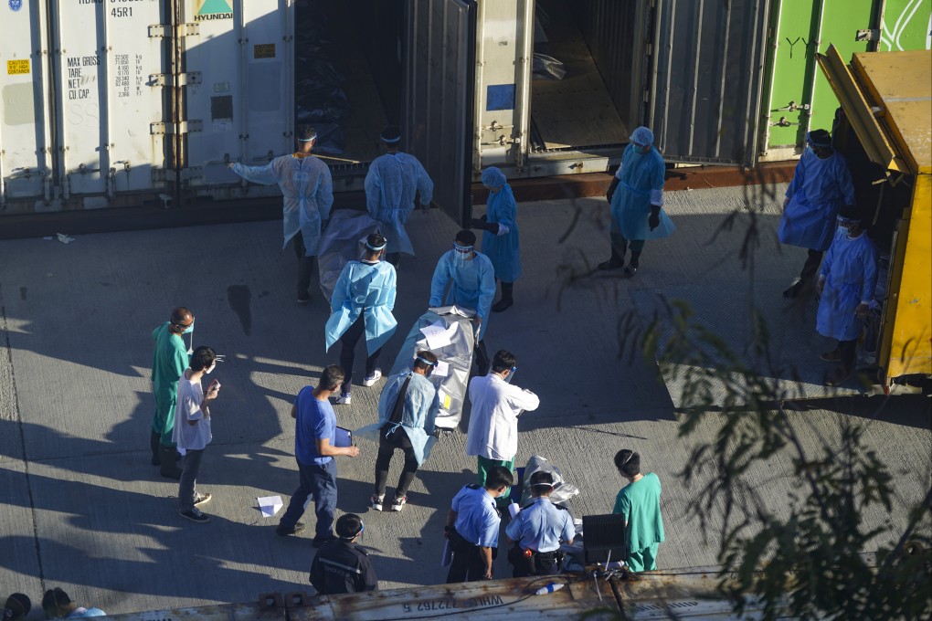 Workers transfer bodies of patients into a refrigerated shipping container outside the Fu Shan Public Mortuary. Photo: Sam Tsang