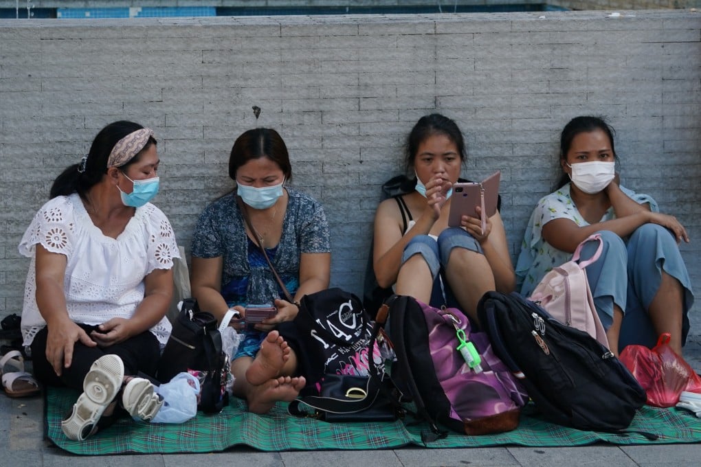 Domestic helpers relax outdoors on a day off. Hong Kong’s 340,000 helpers will miss out on this year’s HK$10,000 consumption voucher handout. Photo: Felix Wong