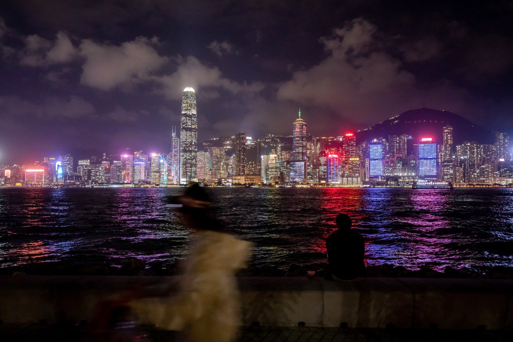 A pedestrian walks along a promenade in front of the city’s skyline in Hong Kong. Photo: Bloomberg