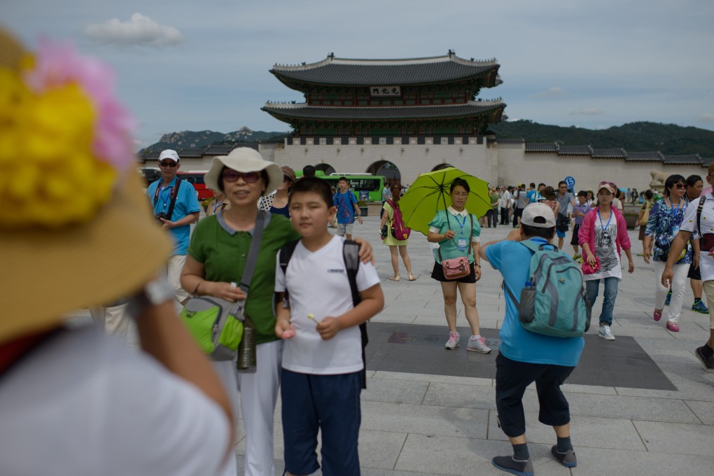 Tourists pose for photos at Gyeongbokgung Palace in Seoul in 2014. South Korea will start allowing vaccinated visitors to enter without quarantine from April 1. Photo: AFP