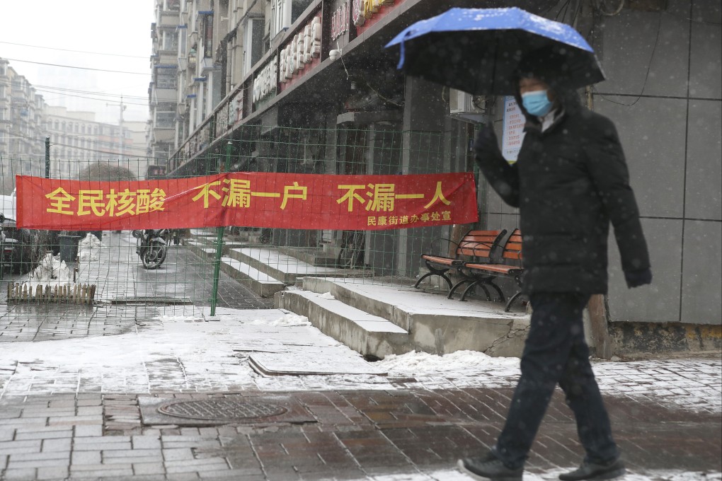 A man walks past a banner reading “Universal Covid-19 test, don’t miss any household, don’t miss any person” amid a citywide lockdown in Changchun, Jilin province. Photo: AP