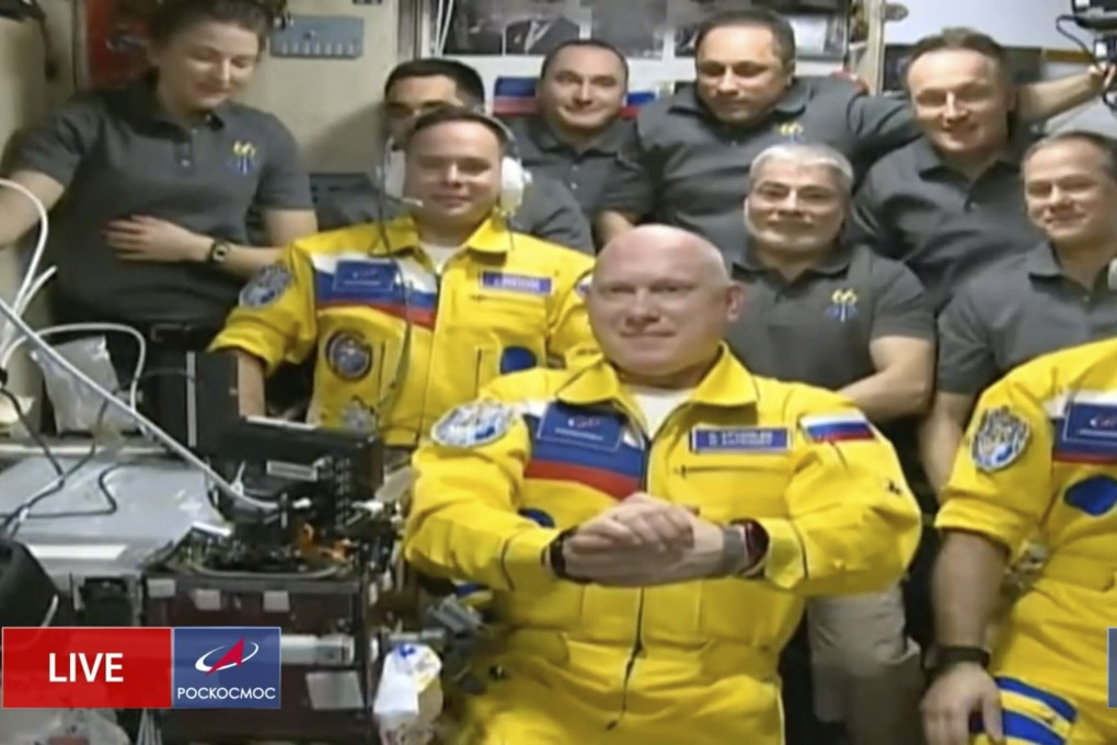Russian cosmonauts Sergey Korsakov, Oleg Artemyev and Denis Matveyev are seen during a welcome ceremony after arriving at the International Space Station on Friday. The crew emerged from the Soyuz capsule wearing yellow flight suits with blue stripes, the colors of the Ukrainian flag. Photo: Roscosmos via AP