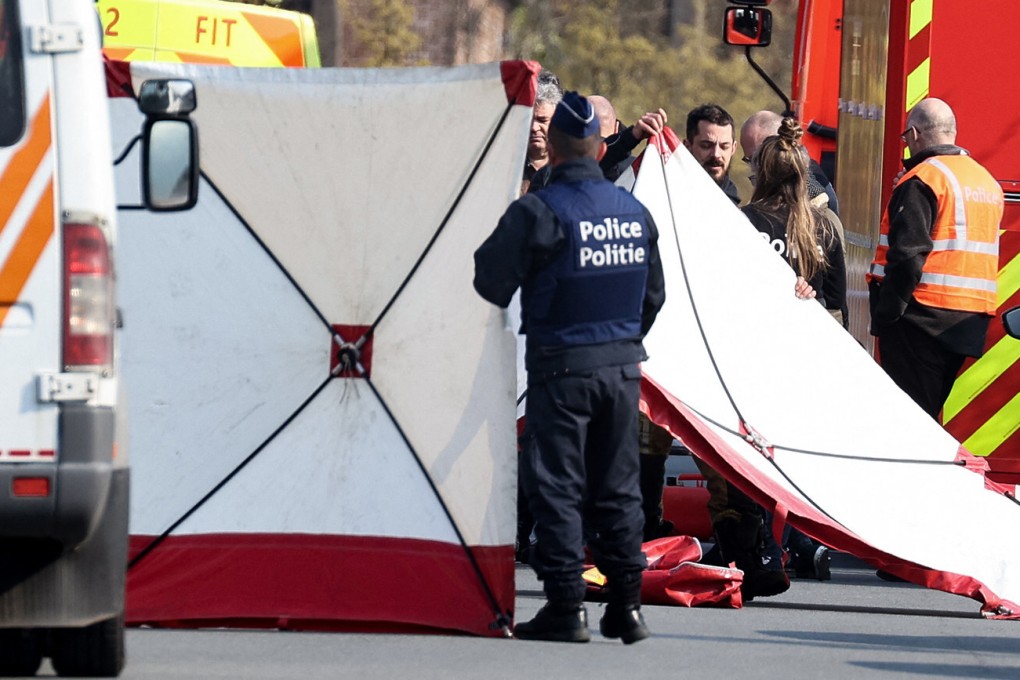 Police erect a white sheet where a car crashed into the crowd. Photo: AFP