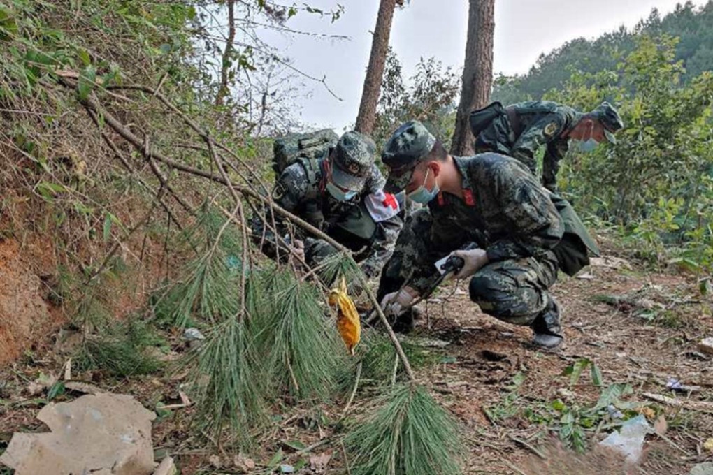 Police officers search the site of the China Eastern Airlines plane crash in southern Guangxi province on Monday. Photo: CNS