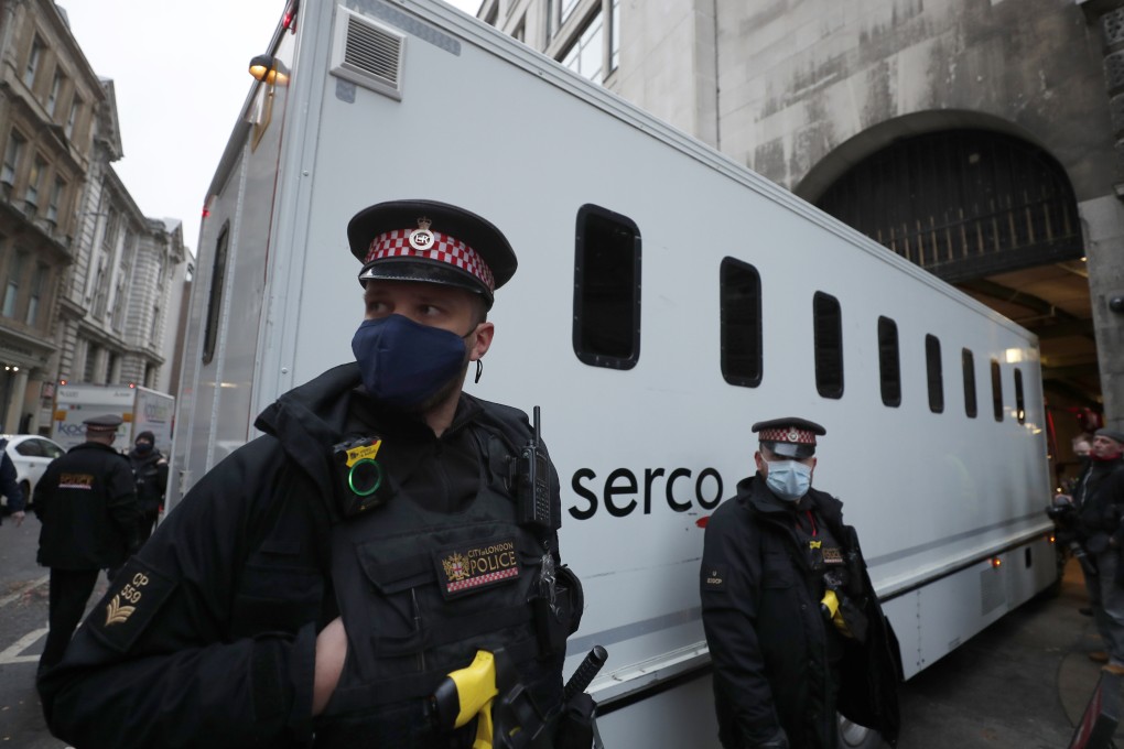 Police guard a prisoner transport van as it arrives at the Old Bailey court in London. Photo: AP