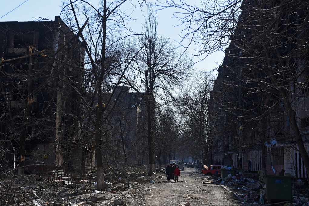 Residents of the southern Ukrainian city of Mariupol walk near residential buildings which were damaged during shelling on March 18. Photo: Reuters