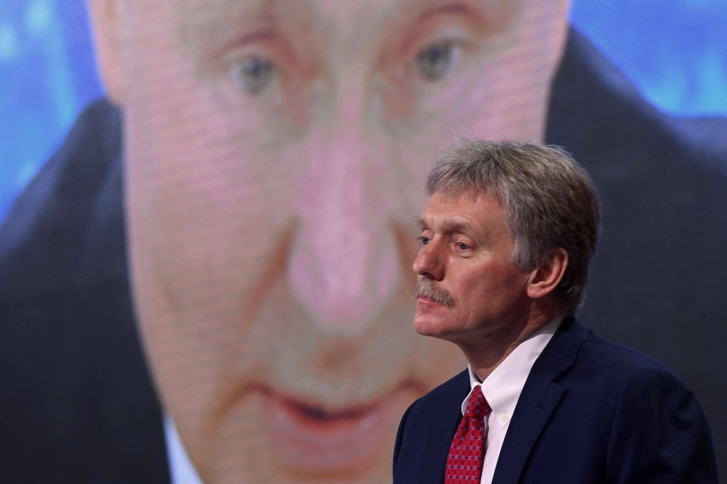 Kremlin spokesman Dmitry Peskov sits in front of a screen in Moscow displaying Russian President Vladimir Putin addressing his annual press conference in December 2020. Photo: AFP