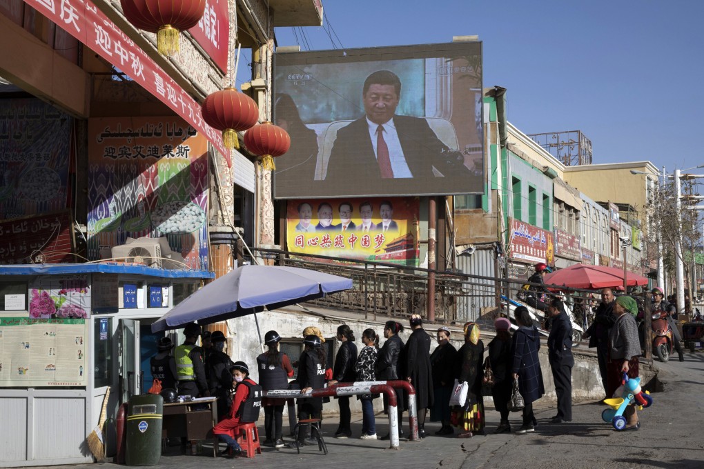 Residents in Hotan queue at a security checkpoint outside a bazaar. Photo: AP