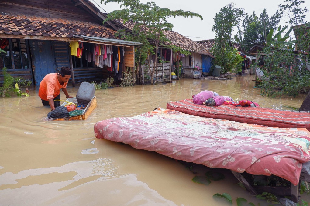 A villager dries items from his flooded house in Sukajaya village in Serang on March 2. The Indonesian city was submerged after days of unusually heavy rainfall earlier this month. Photo: AFP