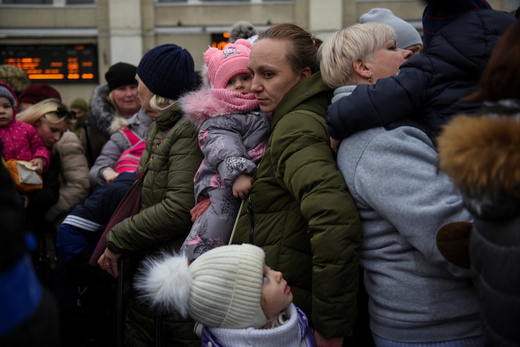 A woman holds her children as civilians fleeing Russia’s invasion of Ukraine wait to board an evacuation train in Odesa on March 16. Photo: Reuters