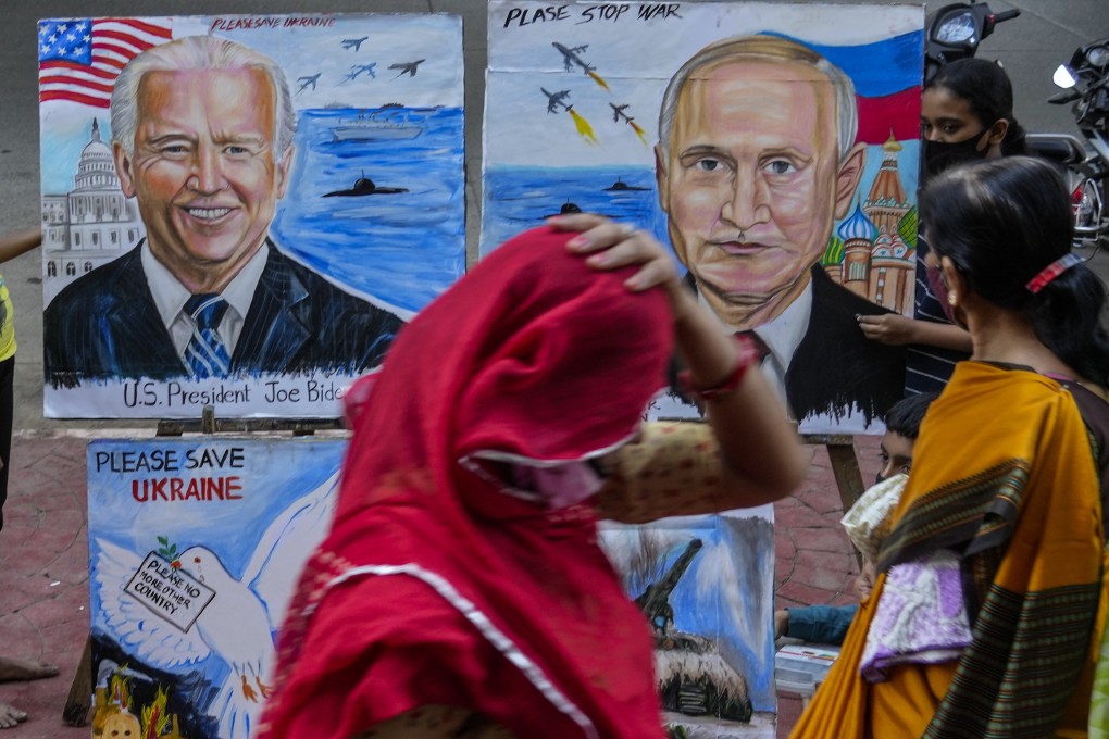 A woman adjusts her sari as she walks past students from an art school displaying their work calling for peace in Ukraine, in Mumbai, India, on February 21. Photo: AP