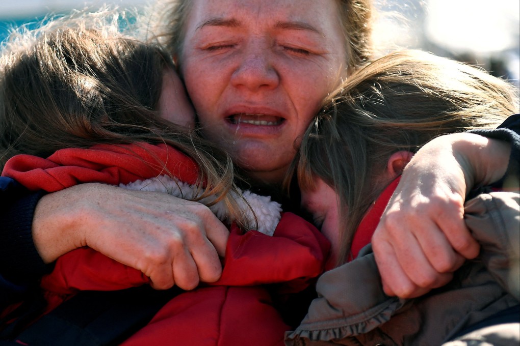 Women from Kharkiv are reunited with a friend on Tuesday after fleeing to Romania from Ukraine. Photo: Reuters