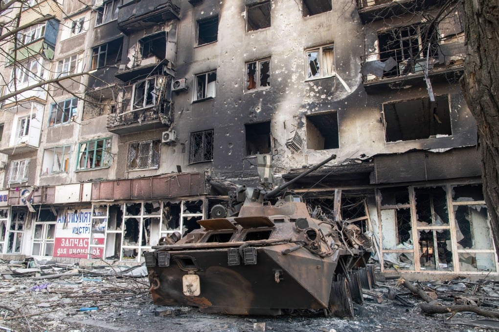 A destroyed wheeled armoured personnel carrier, probably belonging to the defenders of the Azov battalion, lies next to a destroyed residential complex in the besieged Ukrainian city of Mariupol. Photo: dpa