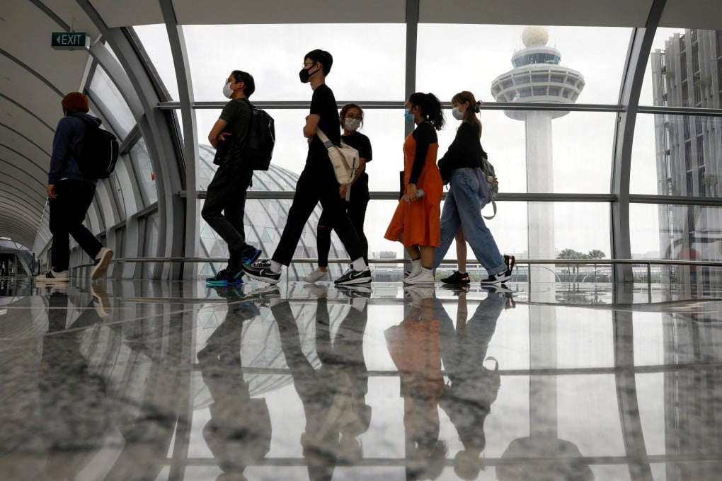 People pass by the control tower in Changi Airport. From March 31, Singapore will allow all fully-vaccinated travellers to enter quarantine-free. Photo: Reuters