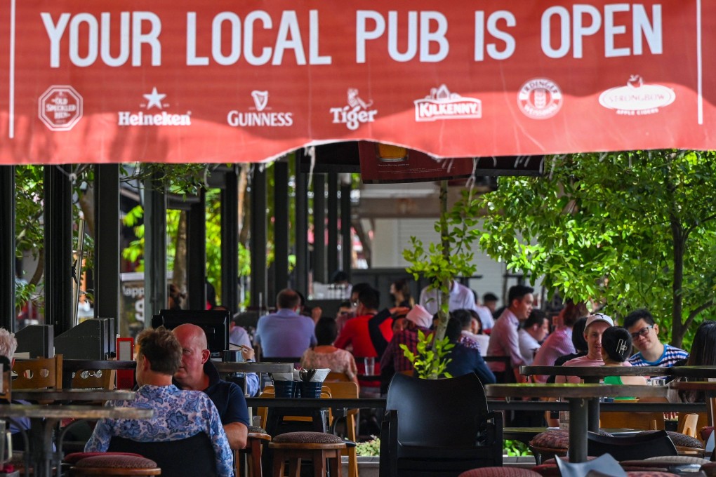 People eat lunch at a restaurant along Boat Quay in Singapore. Photo: AFP