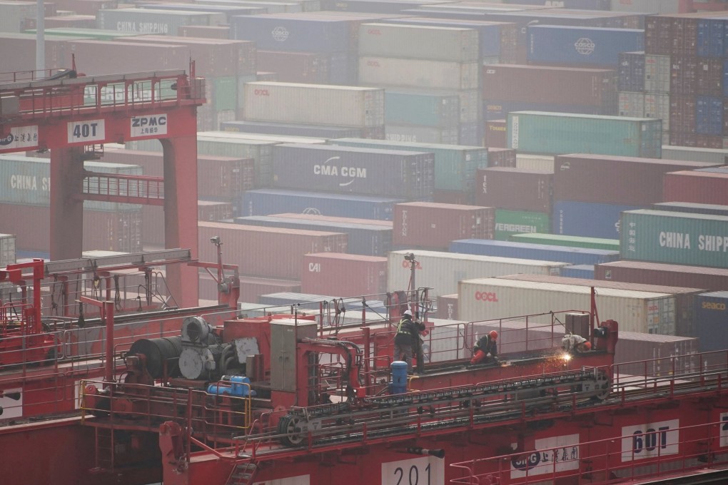 Workers near containers at the Yangshan Deep Water Port in Shanghai in January 2022. Photo: Reuters