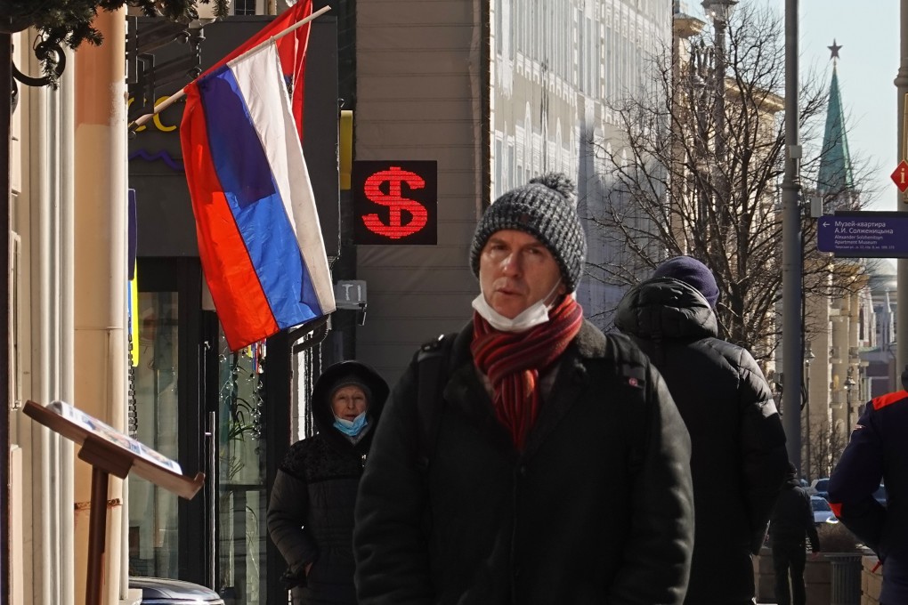 People walk past an electronic panel displaying the dollar sign at an exchange office in Moscow, Russia, on March 10. Photo: EPA-EFE
