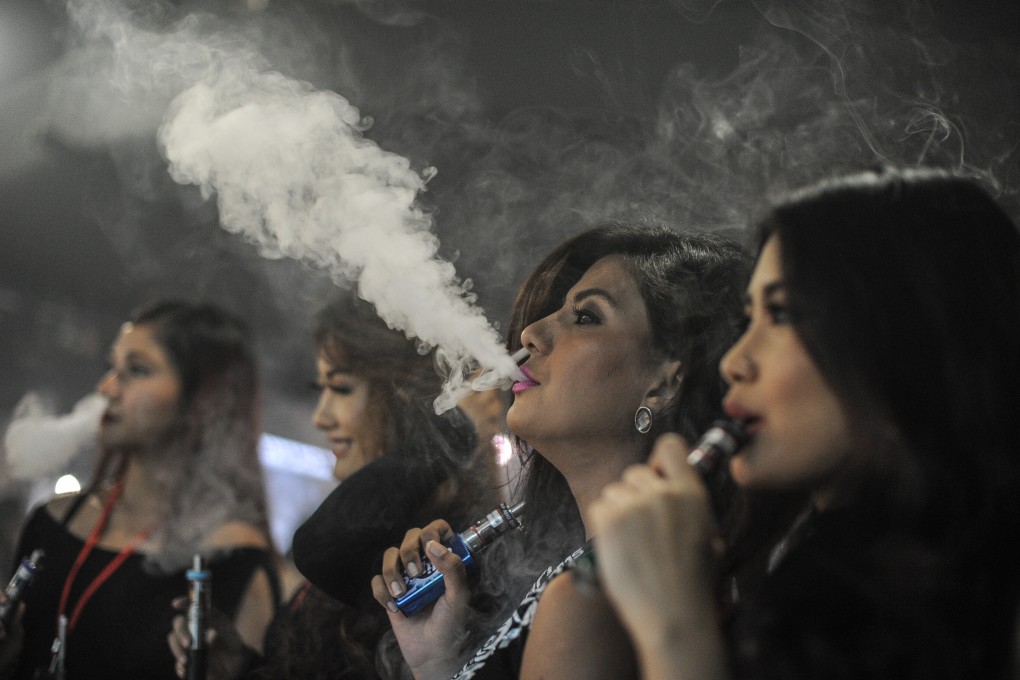 Women smoke electronic cigarettes at the VapeFair in Kuala Lumpur, Malaysia. Photo: AFP